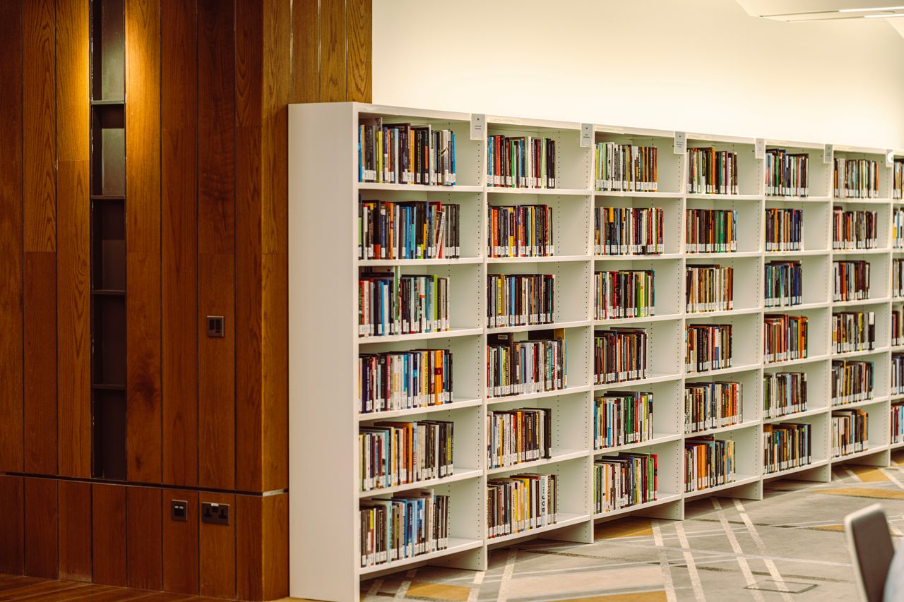A well-organized library interior, showcasing rows of bookshelves stocked with various books in Dubai.