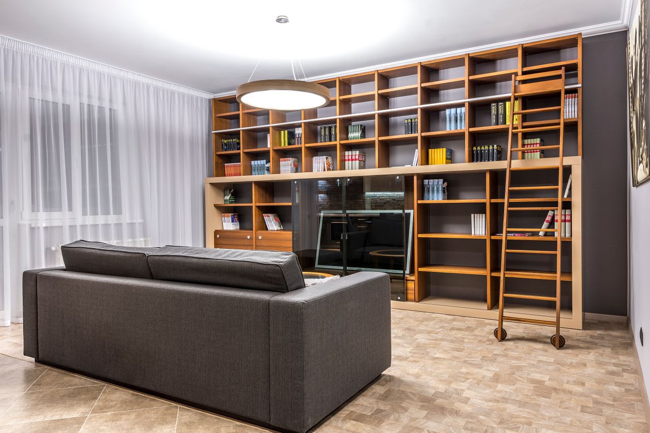 Stylishly designed living room featuring wooden bookshelves and a comfortable sofa.